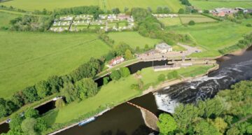 Aerial view of the caravan park with surrounding fields and trees at York Naburn Lock Caravan Park